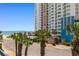 Balcony view of ocean, tower, pool, and palm trees at 1501 S Ocean Blvd. # 351, Myrtle Beach, SC 29577