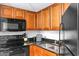 Efficient kitchen features black appliances, wood cabinets, and granite countertops at 1501 S Ocean Blvd. # 351, Myrtle Beach, SC 29577