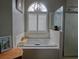 Bright bathroom features a large soaking tub with tile surround, and a modern light fixture at 1635 Southwood Dr., Surfside Beach, SC 29575