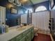 Dark-walled bathroom featuring custom vanity with green cabinets and a shower with a curtain at 1635 Southwood Dr., Surfside Beach, SC 29575