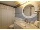 Bathroom with a sink, round mirror and patterned wallpaper at 1690 N Waccamaw Dr. # 504, Garden City Beach, SC 29576