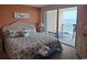 Bedroom with king bed, dresser, and access to balcony with ocean view at 1690 N Waccamaw Dr. # 504, Garden City Beach, SC 29576
