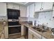 Kitchen with stainless appliances, granite countertops, and white cabinetry at 1690 N Waccamaw Dr. # 504, Garden City Beach, SC 29576