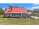 Charming home featuring a red metal roof, cozy front porch, manicured lawn, and classic curb appeal at 1700 Longleaf Dr., Myrtle Beach, SC 29575