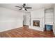 Cozy living room features a white brick fireplace, ceiling fan, and bright natural light at 1700 Longleaf Dr., Myrtle Beach, SC 29575