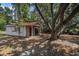 Exterior view of an outbuilding with a red metal roof nestled among mature trees at 1700 Longleaf Dr., Myrtle Beach, SC 29575