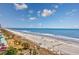 Expansive beach view with people enjoying the sand and surf under a sunny sky at 201 74Th Ave N Ocean Blvd. # 2627, Myrtle Beach, SC 29572