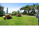 Outdoor common area with picnic tables, grill, green lawn, and manicured trees at 201 76Th Ave. N # D-3, Myrtle Beach, SC 29572