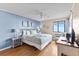 Inviting main bedroom with serene blue walls, ceiling fan, comfortable bed, and ocean view at 201 76Th Ave. N # D-3, Myrtle Beach, SC 29572