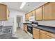 Galley kitchen with wood cabinets, black countertops, and access to the laundry area at 2061 Silvercrest Dr. # 7E, Myrtle Beach, SC 29579