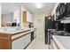 Well-lit kitchen features white cabinets, tiled floors, and essential appliances at 2280 Andover Dr. # C, Surfside Beach, SC 29575