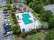 Aerial view of community pool area, including a clubhouse, parking, and lounge seating near a lake at 2280 Andover Dr. # C, Surfside Beach, SC 29575