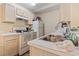 Galley kitchen with white appliances and light wood cabinetry at 2280 Andover Dr. # L, Surfside Beach, SC 29575