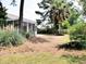 A yard with grass, a patio, trees, and partial view of the house at 230 Vermillion Dr., Little River, SC 29566