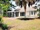 A well-maintained backyard with a patio, screened porch, and mature landscaping at 230 Vermillion Dr., Little River, SC 29566