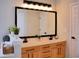 Modern bathroom with a double sink, wood cabinets, and a large mirror at 230 Vermillion Dr., Little River, SC 29566