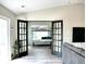 View of a bunk-bed bedroom with french doors and view to the living room at 230 Vermillion Dr., Little River, SC 29566
