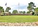 Community sign for Hidden Lakes Village with beautiful landscaping and flags at 230 Vermillion Dr., Little River, SC 29566