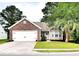Charming single-story home with brick accents, a well-manicured lawn, and an attached two-car garage at 230 Vermillion Dr., Little River, SC 29566