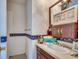Bathroom with a single sink vanity, decorative mirror, and blue floral border at 2309 Withers Dr. # 4, Myrtle Beach, SC 29577