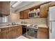 Kitchen with wooden cabinetry, white countertop and appliances, including a microwave and oven at 2309 Withers Dr. # 4, Myrtle Beach, SC 29577