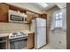 Cozy kitchen with vintage wood cabinets, white appliances and floral wallpaper at 2309 Withers Dr. # 4, Myrtle Beach, SC 29577