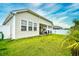 Spacious, grassy backyard with covered patio, outdoor seating, and palm tree at 234 Rolling Woods Ct., Little River, SC 29566