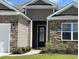 Inviting front door with stone veneer and manicured bushes and garden at 234 Rolling Woods Ct., Little River, SC 29566