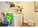 Bright laundry room with washer, dryer, storage shelves, and hanging rack at 234 Rolling Woods Ct., Little River, SC 29566