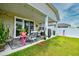 Covered patio with outdoor seating and grill overlooking the grassy backyard at 234 Rolling Woods Ct., Little River, SC 29566