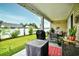 Covered patio with outdoor seating and grill, overlooking the manicured backyard at 234 Rolling Woods Ct., Little River, SC 29566
