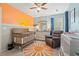Bedroom features a whimsical sun mural, a gray crib, comfortable rocker, and ample natural light at 2487 Windmill Way, Myrtle Beach, SC 29579