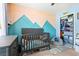 Cozy Bedroom features a charming mountain mural, a gray crib full of stuffed animals, and an organized closet at 2487 Windmill Way, Myrtle Beach, SC 29579
