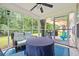 Relaxing screened-in porch with a covered table and wicker sofa, perfect for enjoying the outdoors at 2487 Windmill Way, Myrtle Beach, SC 29579
