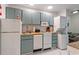 Modern kitchen with blue cabinets, white appliances and combined washer/dryer for added convenience at 2710 S Ocean Blvd. # 402, Myrtle Beach, SC 29577