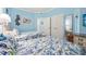Comfortable bedroom featuring two beds, blue bedding, light blue walls, and a partial view of the TV at 300 N Ocean Blvd. # 122, North Myrtle Beach, SC 29582
