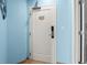 Hallway with an exit door featuring an electronic lock, tile floor and blue painted walls at 300 N Ocean Blvd. # 122, North Myrtle Beach, SC 29582