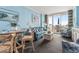 Charming living room with coastal decor, a cozy sofa, and a dining area with a view of the oceanfront balcony at 300 N Ocean Blvd. # 122, North Myrtle Beach, SC 29582