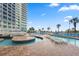 Outdoor pool featuring lounge chairs, palm trees, and resort in the background at 300 N Ocean Blvd. # 122, North Myrtle Beach, SC 29582