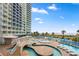 Expansive pool area with lounge chairs, and lush tropical landscaping, creating a resort-like experience at 300 N Ocean Blvd. # 122, North Myrtle Beach, SC 29582