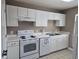 Close-up of a kitchen with white cabinetry, appliances, countertop, and stainless steel sink at 300-J Myrtle Greens Dr. # J, Conway, SC 29526