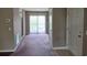 Open-plan living space with carpet, entrance door, and sliding glass door with vertical blinds at 300-J Myrtle Greens Dr. # J, Conway, SC 29526