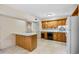 Eat-in kitchen boasts wood cabinets, white appliances and tile flooring at 308 76Th Ave. N # 5, Myrtle Beach, SC 29572