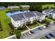 Aerial view of a condo building with a parking lot, a pond, and surrounding greenery at 340 Kiskadee Loop, Conway, SC 29526