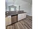 Kitchen with granite countertops, stainless steel dishwasher, white cabinets, and wood-look flooring at 340 Kiskadee Loop, Conway, SC 29526