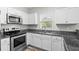 Bright kitchen featuring stainless steel appliances, granite countertops, and white cabinets at 340 Kiskadee Loop, Conway, SC 29526
