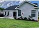 View of the home’s back yard and patio with seating and landscaped flowerbeds at 387 Blue Rock Dr., Longs, SC 29568