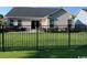 View of the home’s backyard with black metal fencing and patio at 387 Blue Rock Dr., Longs, SC 29568