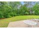 Lush backyard with mature trees, grassy lawn, and patio area with an outdoor table and seating at 396 Mckendree Ln., Myrtle Beach, SC 29579
