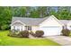 Home exterior featuring a well-maintained lawn, landscaping, and attached two car garage at 396 Mckendree Ln., Myrtle Beach, SC 29579